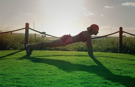 Woman doing push-ups in the grass